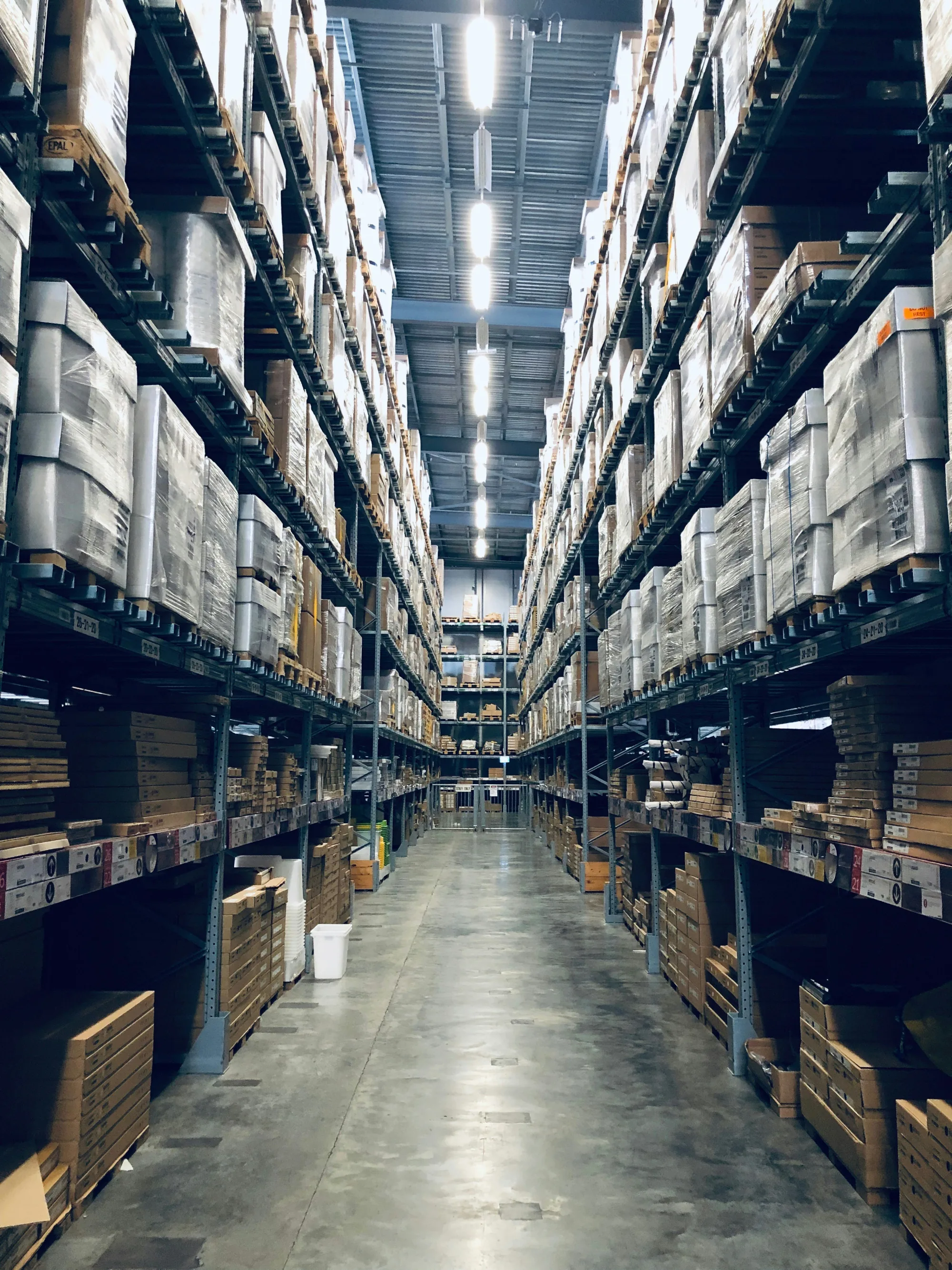 Allée d'un entrepôt logistique avec des rayonnages remplis de cartons